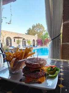 a plate of food with a hamburger and french fries at Riad Eucalyptus by Caravanserail in Essaouira