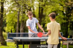 two boys playing ping pong on a ping pong table at Chateau Melay in Melay