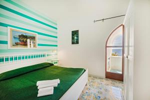 Un dormitorio con una cama verde y una ventana en Marina del Cantone Chalet, en Nerano