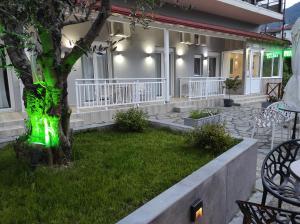 uma casa com luz verde à volta de uma árvore em Ενοικιαζόμενα Δωμάτια Ενιπεύς- Rooms Enipeas em Litochoro