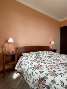 um quarto com uma cama com um edredão floral em Villa Barelli em Cabris