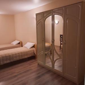 a room with two beds and a glass closet at Готельно- банний комплекс Афродіта in Nyzhni Mlyny
