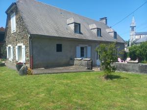 a small stone house with a yard with a grass yard at Maison avec jardin in Adé