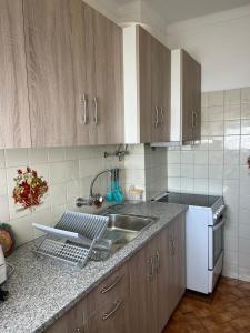 アルブフェイラにあるCasa d'Avó by RPG Propertiesのシンクとカウンタートップのあるキッチン +3枚の写真