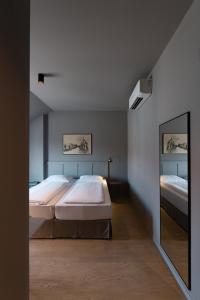 1 Schlafzimmer mit 2 Betten und einem Spiegel in der Unterkunft Luis von Weyden in Weiden am See