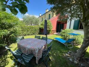 einen Tisch, Stühle und einen Regenschirm im Hof in der Unterkunft LunaSole Casa vacanza mare in Aprilia Marittima