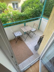 a patio with two chairs and a table on a balcony at cozy apartment close to vienna in Brunn am Gebirge