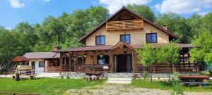 una baita di tronchi con veranda e cortile di Cabana Lunca a Târgu Neamț
