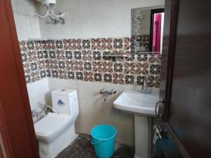 uma casa de banho com um lavatório, um WC e um espelho. em Pal Homestay Shimla em Shimla