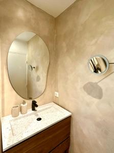 W łazience znajduje się umywalka i lustro. w obiekcie Window On Ramatuelle w Saint-Tropez