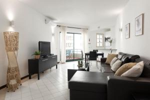 a living room with a couch and a tv at Algamar Apartment - Vilamoura Center in Vilamoura