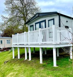 a house with a white deck on the grass at Rockley Park Private Holiday Homes in Poole