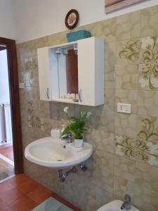 a bathroom with a sink and a clock on the wall at Casa di Marisa in Trevignano Romano