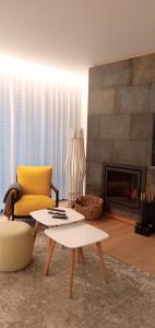 a living room with a yellow chair and a fireplace at Casa do Escorrega in Grândola