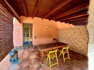 Habitación con mesa de madera y 2 sillas amarillas. en Villa Petrelli, en Torre dell'Orso