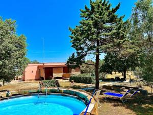 una piscina en un patio con un árbol en Villa Petrelli, en Torre dell'Orso