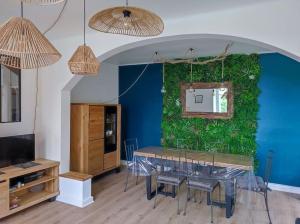 Pokój ze stołem i zieloną ścianą w obiekcie Maison avec jardin w mieście Pleumeur-Gautier