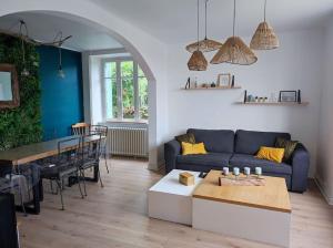 salon z niebieską kanapą i stołem w obiekcie Maison avec jardin w mieście Pleumeur-Gautier