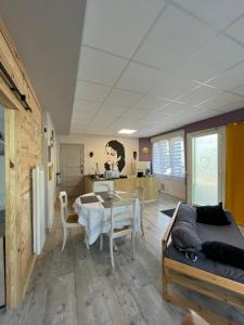 ein Wohnzimmer mit einem Tisch und einem Esszimmer in der Unterkunft Chez Léandre in Vitry-le-François