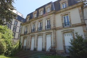 an old building with stairs in front of it at Le Gentiane - Villa Chanterive in La Bourboule