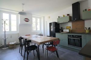 a kitchen with a wooden table and chairs at Le Gentiane - Villa Chanterive in La Bourboule