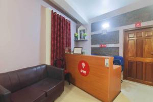 uma sala de espera com um sofá de couro e uma secretária em Am Bed And Breakfast em Shillong