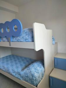 una camera con 2 letti a castello con lenzuola blu di Appartamenti Orizzonti a Tortoreto