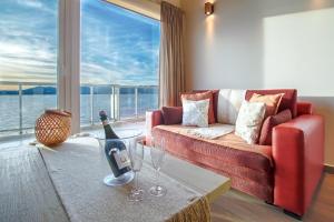 a living room with a red couch and a large window at Bariloche costa del lago Ollagua in San Carlos de Bariloche