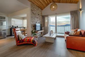 Una sala de estar con vista al mar. en Bariloche costa del lago Ollagua, vista al lago panoramica, piscina, cochera, en San Carlos de Bariloche