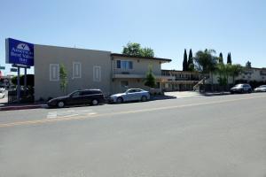 um grupo de carros estacionados ao lado de uma rua em Americas Best Value Inn Visalia em Visalia