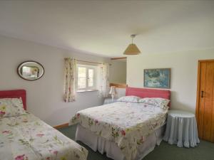 a bedroom with two beds and a window at Millwater Cottage in Axminster