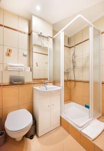a bathroom with a shower and a toilet and a sink at Metro Rondo ONZ Yellow Apartment in Warsaw