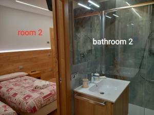 a bathroom with a sink and a shower at Appartamento Mansarda Patrizia e Franco Val di Sole in Deggiano
