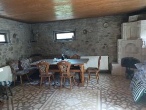 een eetkamer met een tafel en stoelen en een open haard bij Casa de pe lac Fedelesoiu , in Râmnicu Vâlcea