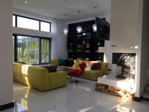 un soggiorno con divano giallo e camino di Villa Solva a Golubinoye