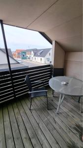 balcón con mesa, mesa y silla en Nr. Nebel Minimarked, en Nørre Nebel