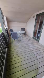 a balcony with a table and chairs in a building at Nr. Nebel Minimarked in Nørre Nebel