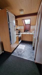 a kitchen with a white refrigerator and a window at Nr. Nebel Minimarked in Nørre Nebel