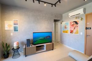 a living room with a flat screen tv on a wall at PALMAS EXPERIENCE - APARTAMENTO VISTA LAGO, próximo ao shopping in Palmas