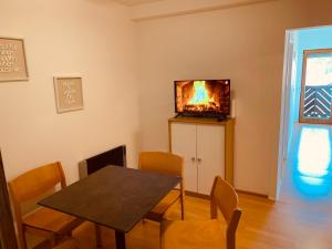 comedor con mesa y TV en la pared en FELIX LIVING 6, modern & cozy 3 Zimmer Wohnung, Balkon, Parkplatz, en Salzweg