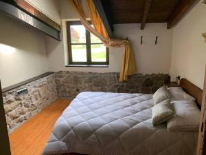 a bedroom with a large bed and a window at La Fontanina de Mario in Villaviciosa