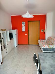 un soggiorno con divano e parete rossa di Appartamenti Orizzonti a Tortoreto