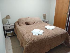 1 dormitorio con 1 cama con 2 toallas en Libertad en Villa Yacanto