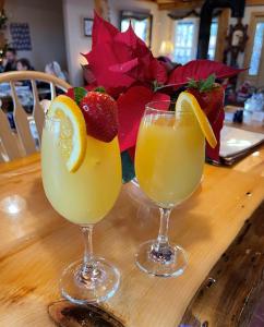 two glasses of oranges and strawberries on a wooden table at Blueberry Fields Bed & Breakfast in Jefferson