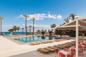 a pool at a resort with chairs and umbrellas at ALOHA PUERTO PRIVATE APARTMENT 1st line Carihuela Beach in Torremolinos