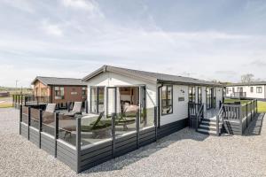 een modulair huis met een veranda en een terras bij Stewarts Resort Lodge 52 in St Andrews