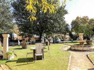 un parque con una mesa, sillas y una fuente en The Green Acorn Guest House, en Ficksburg