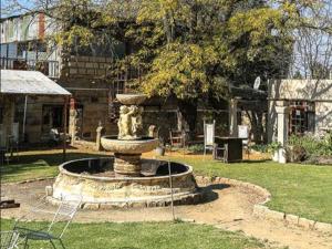 a fountain in the middle of a yard at The Green Acorn Guest House in Ficksburg