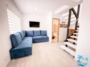 a living room with a blue couch and a staircase at Casa Turística Praia House in San Andrés