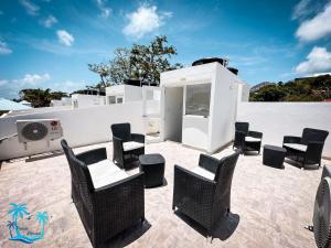 un grupo de sillas y mesas en un patio en Casa Turística Praia House en San Andrés